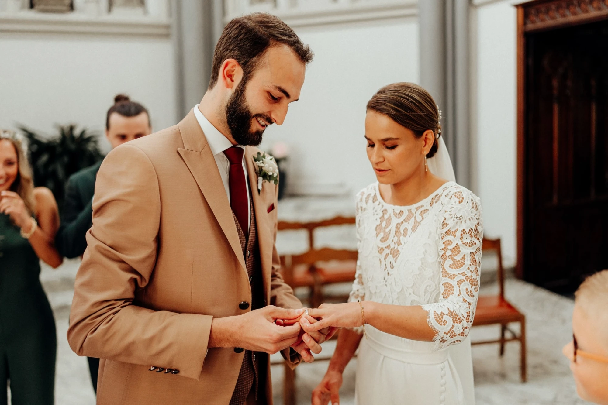Échange d'alliances élégant : le marié glisse l'alliance au doigt de la mariée. photographe-lille