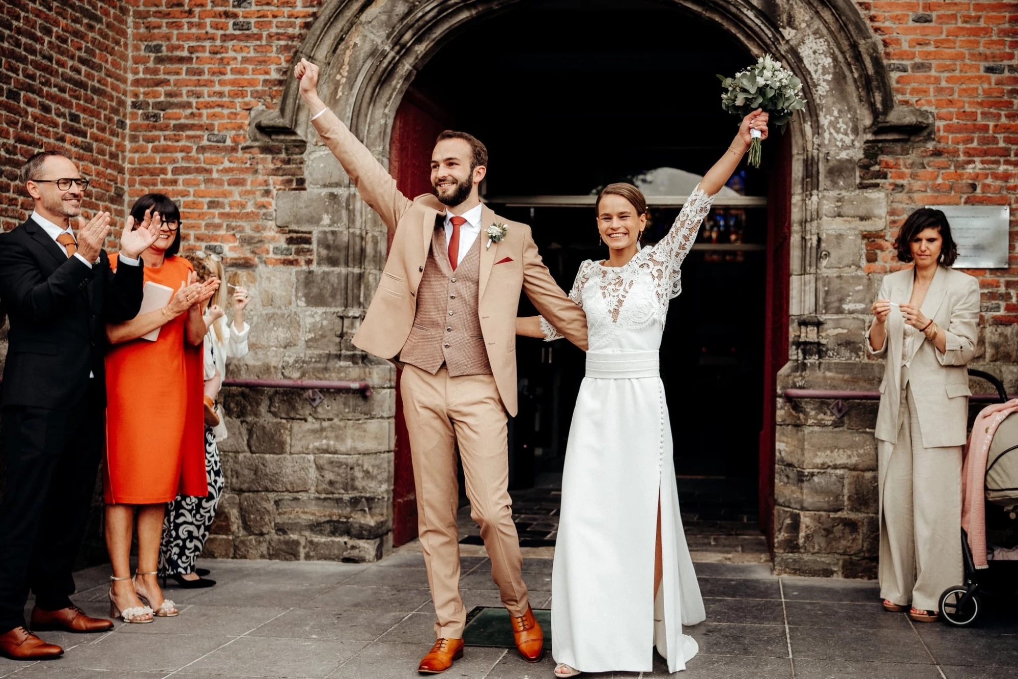 Mariés célébrant leur mariage en Belgique, applaudis par leurs proches. photographe-lille