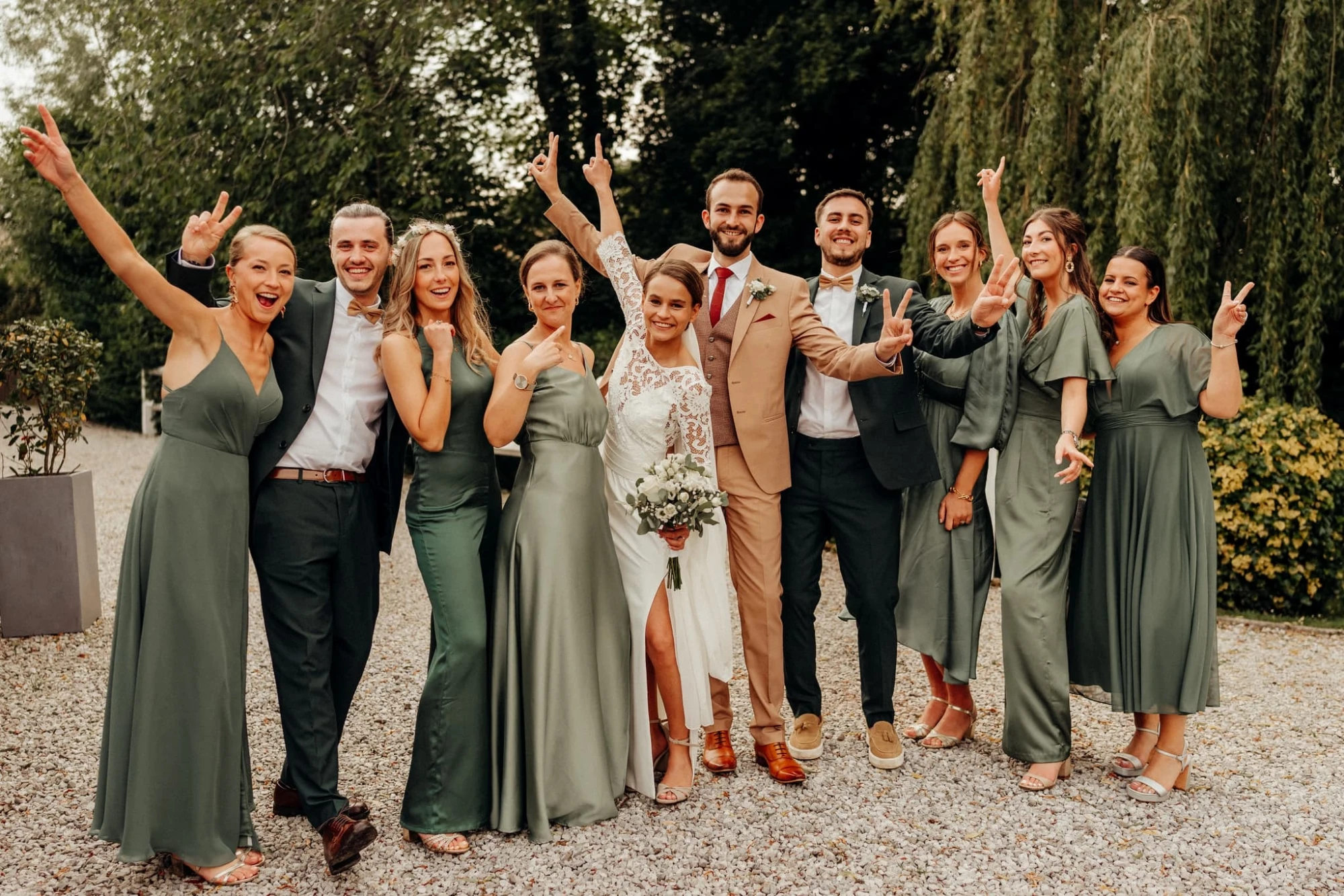 Groupe de mariage souriant devant un lieu de mariage en plein air. photographe-lille