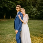 Jeune couple marié : la mariée appuie sa tête sur l'épaule du marié dans un cadre champêtre. photographe-lille