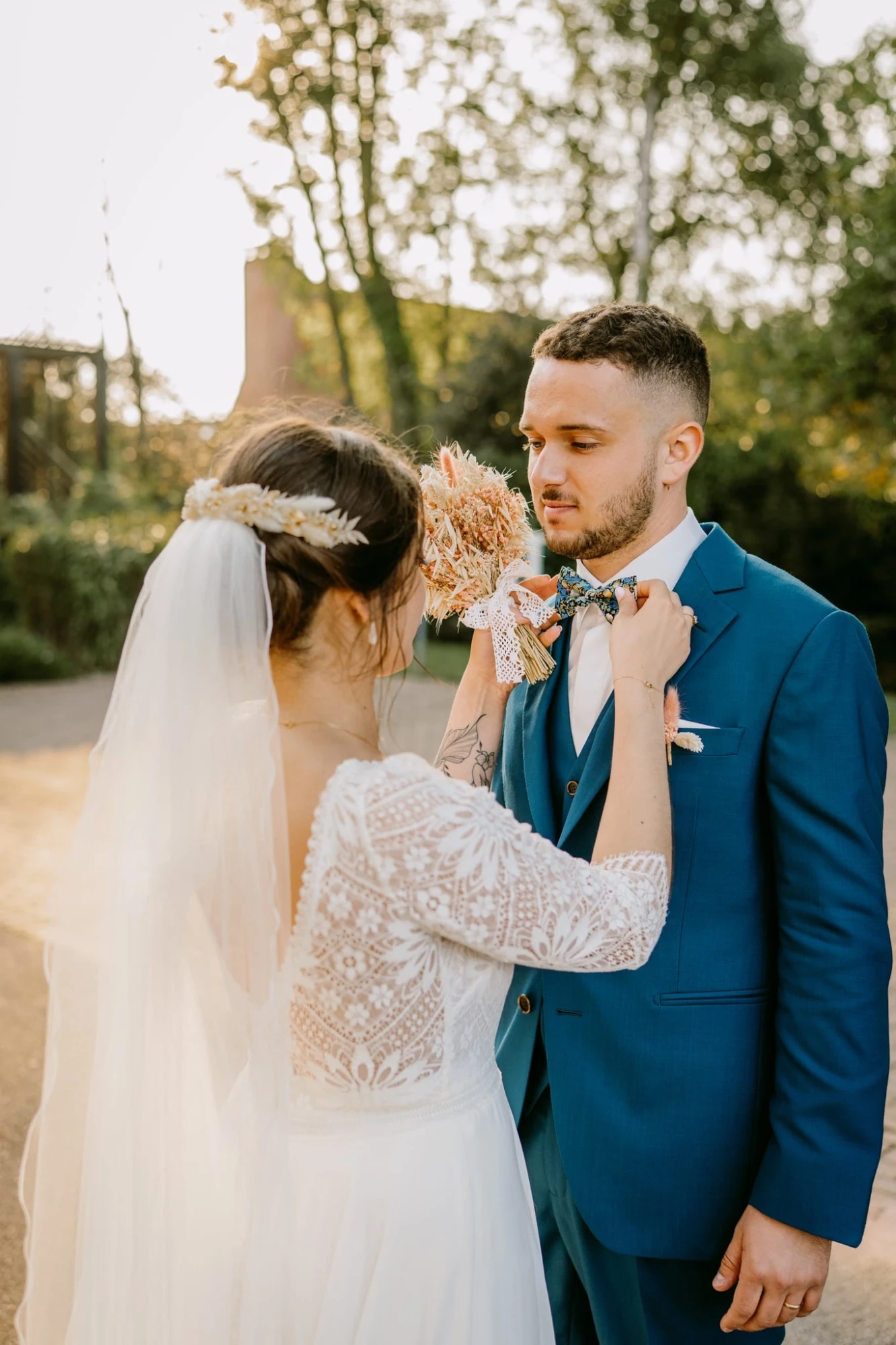 Mariage champêtre : La mariée ajuste le nœud papillon du marié. Amour et tendresse. photographe-lille