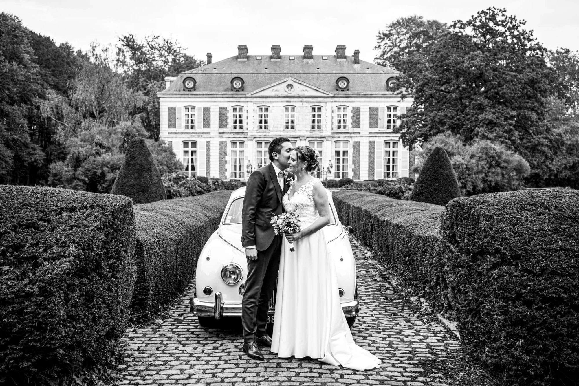 Couple marié devant une Coccinelle vintage et un château, mariage romantique. photographe-lille