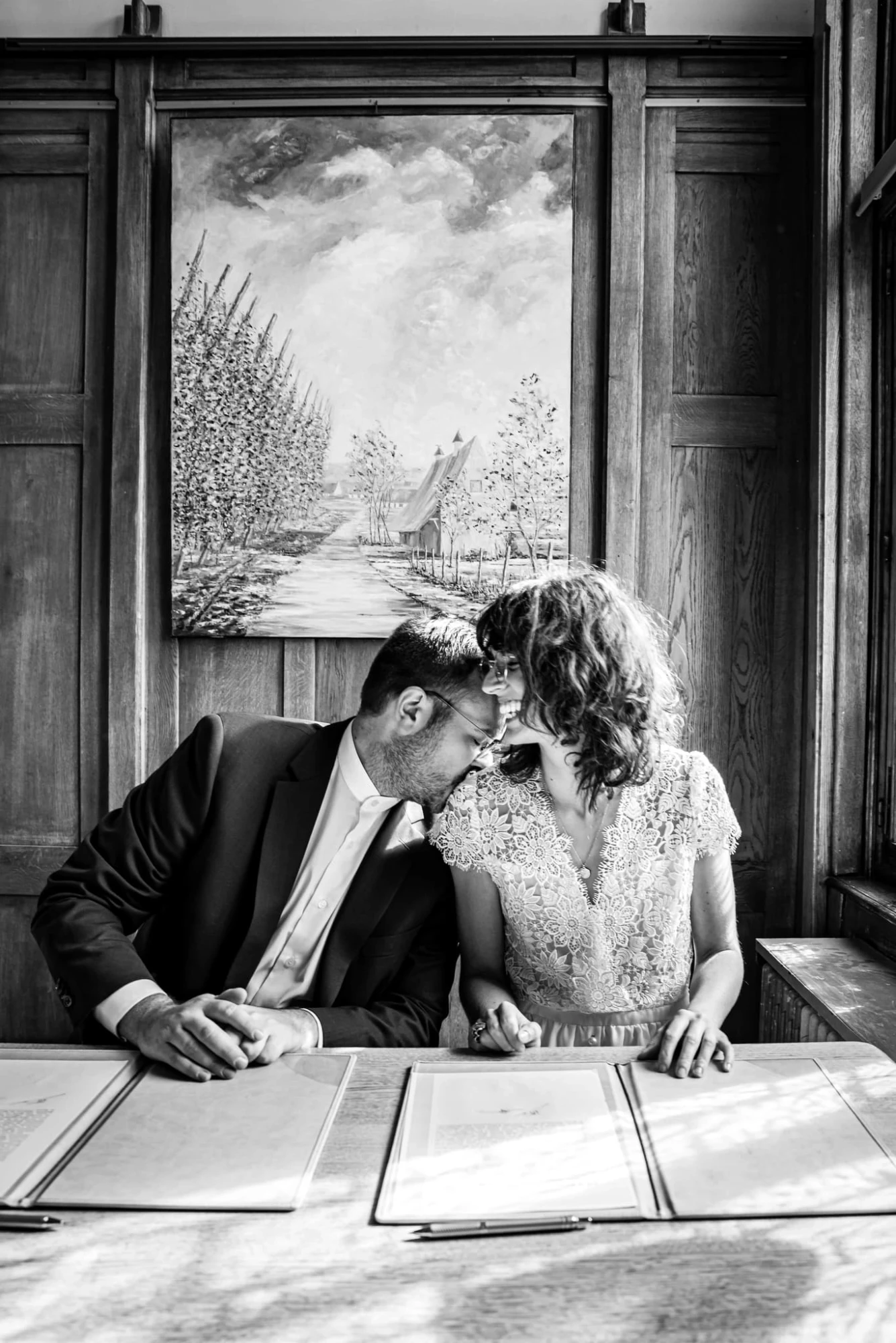 Couple marié s'embrassant devant un tableau lors d'une cérémonie de mariage civile. photographe-lille