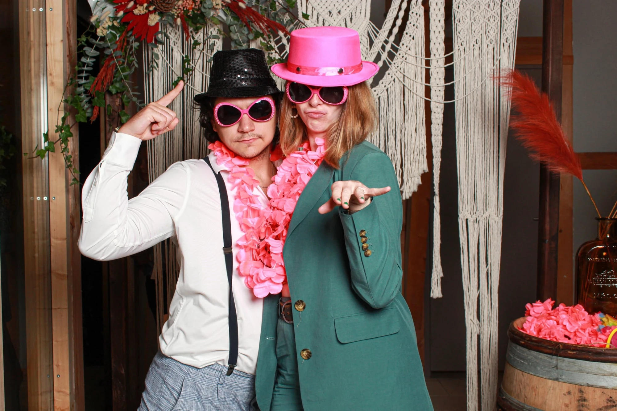 Couple déguisé avec chapeaux roses et noirs, lunettes de soleil et colliers de fleurs roses. photographe-lille