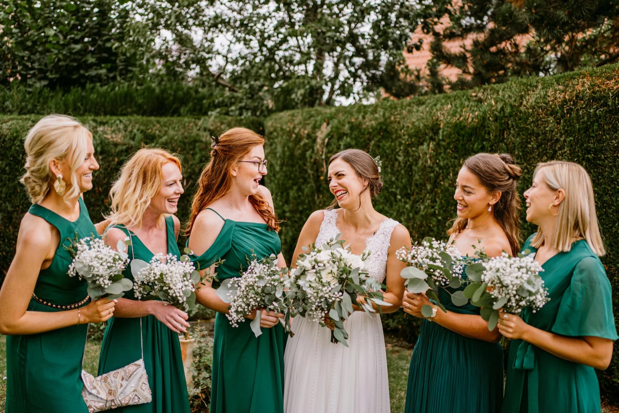 Mariée et demoiselles d'honneur en robes vertes souriant avec des bouquets. photographe-lille
