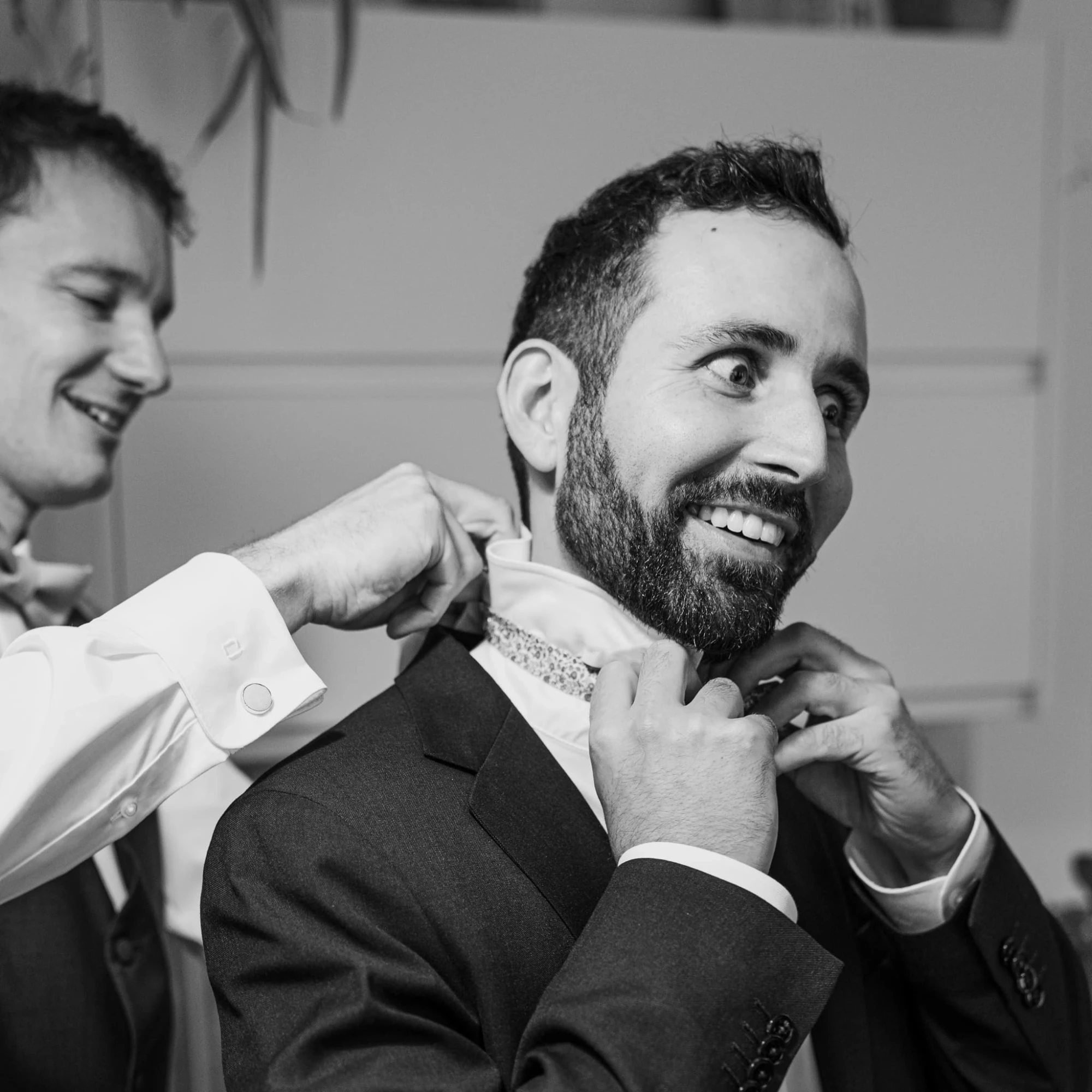 Homme aidant un marié à ajuster son nœud papillon avant la cérémonie. Préparatifs du mariage. photographe-lille