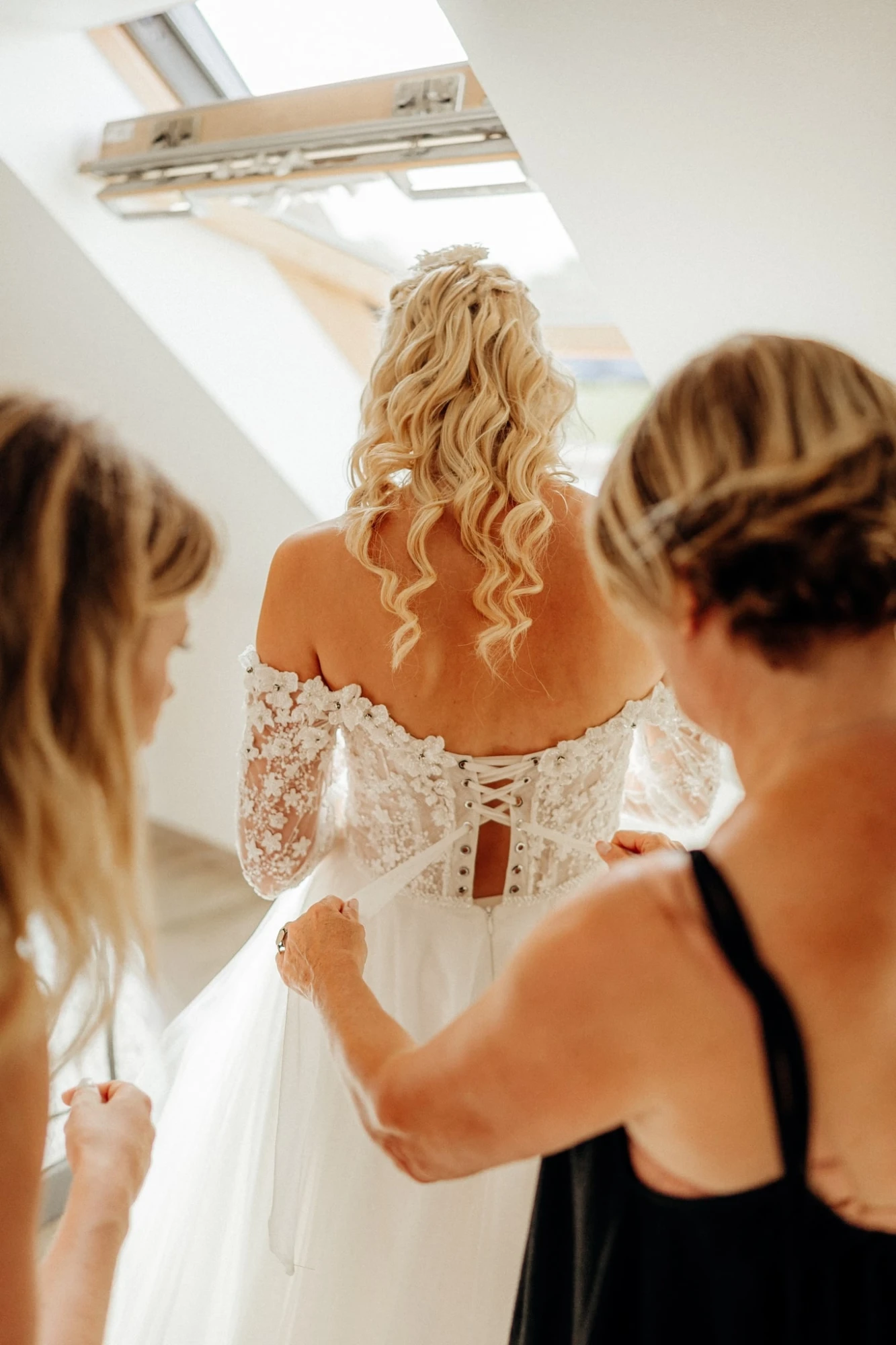 Femme en robe de mariée, aidée à lacer son corset. Préparatifs mariage. photographe-lille
