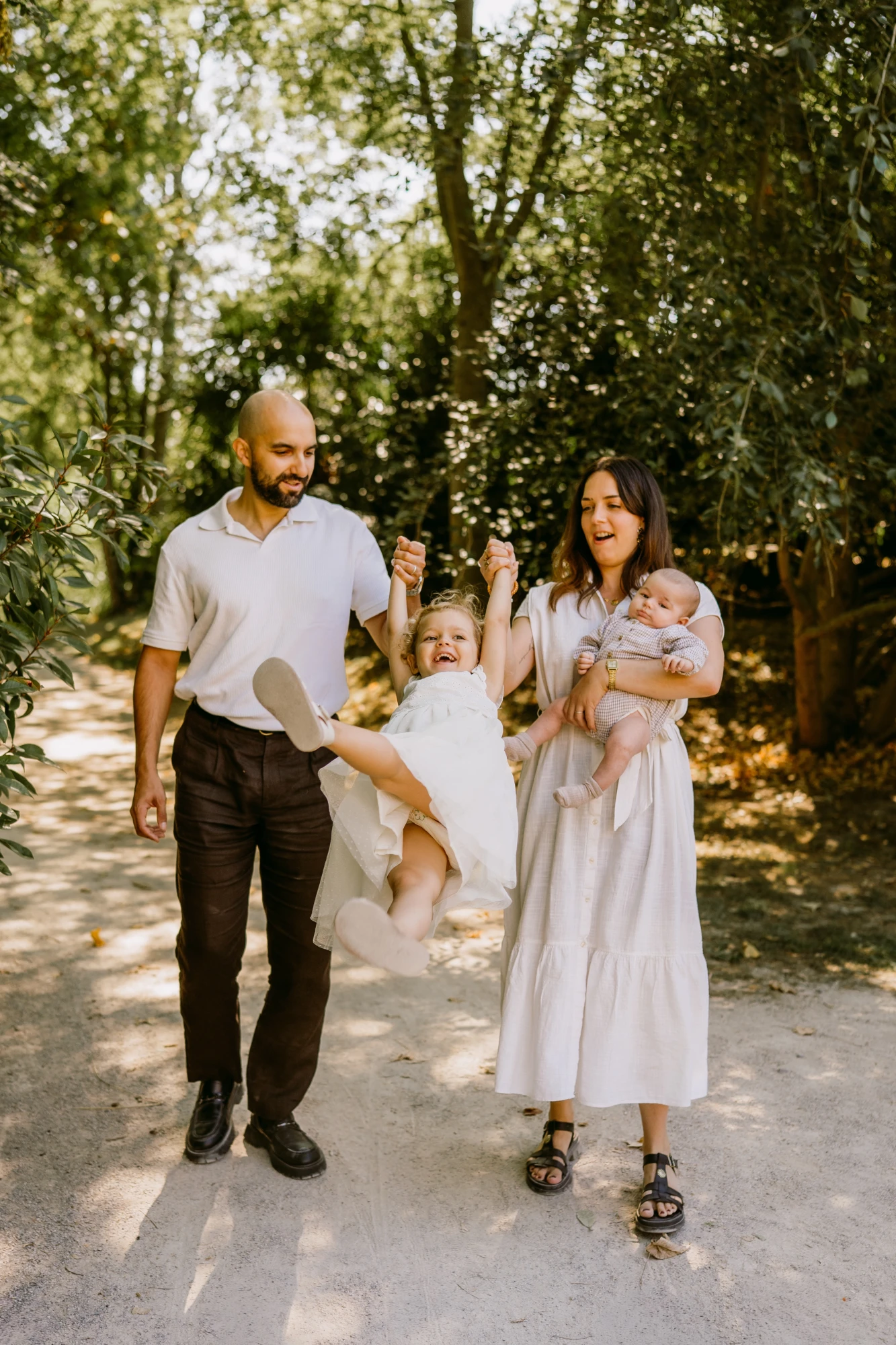 Famille heureuse se promenant dans un parc : père, mère, fille et bébé. photographe-lille