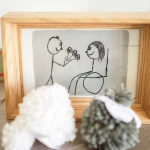 Dessin enfantin encadré : homme offrant des fleurs à une femme assise. Cadeau fait main. photographe-lille