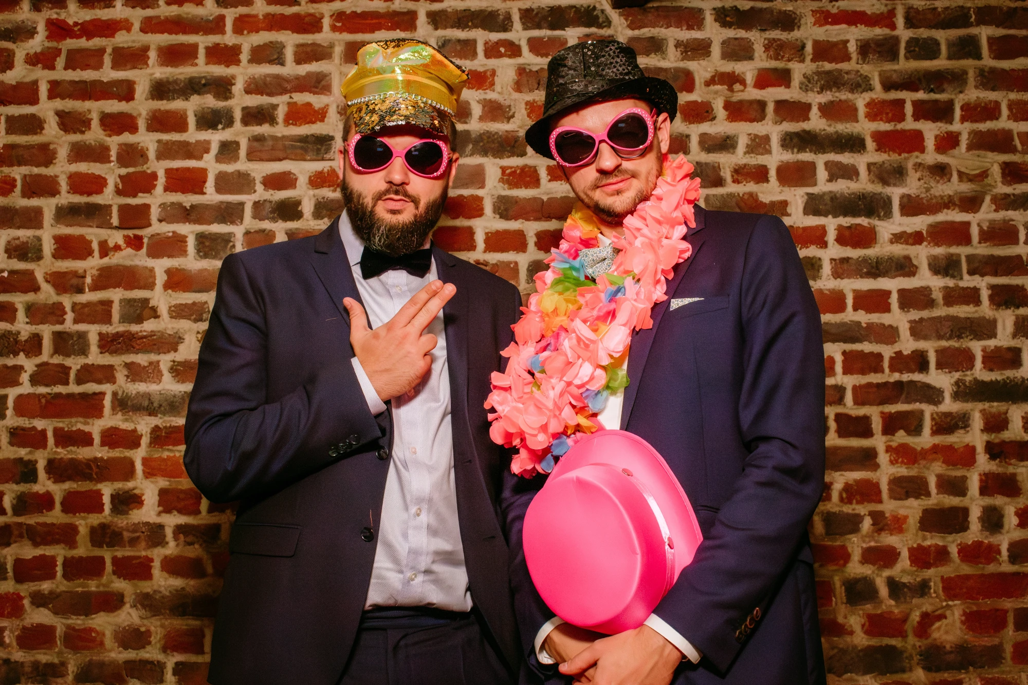 Deux hommes déguisés devant un mur de briques, accessoires de photobooth amusants. photographe-lille