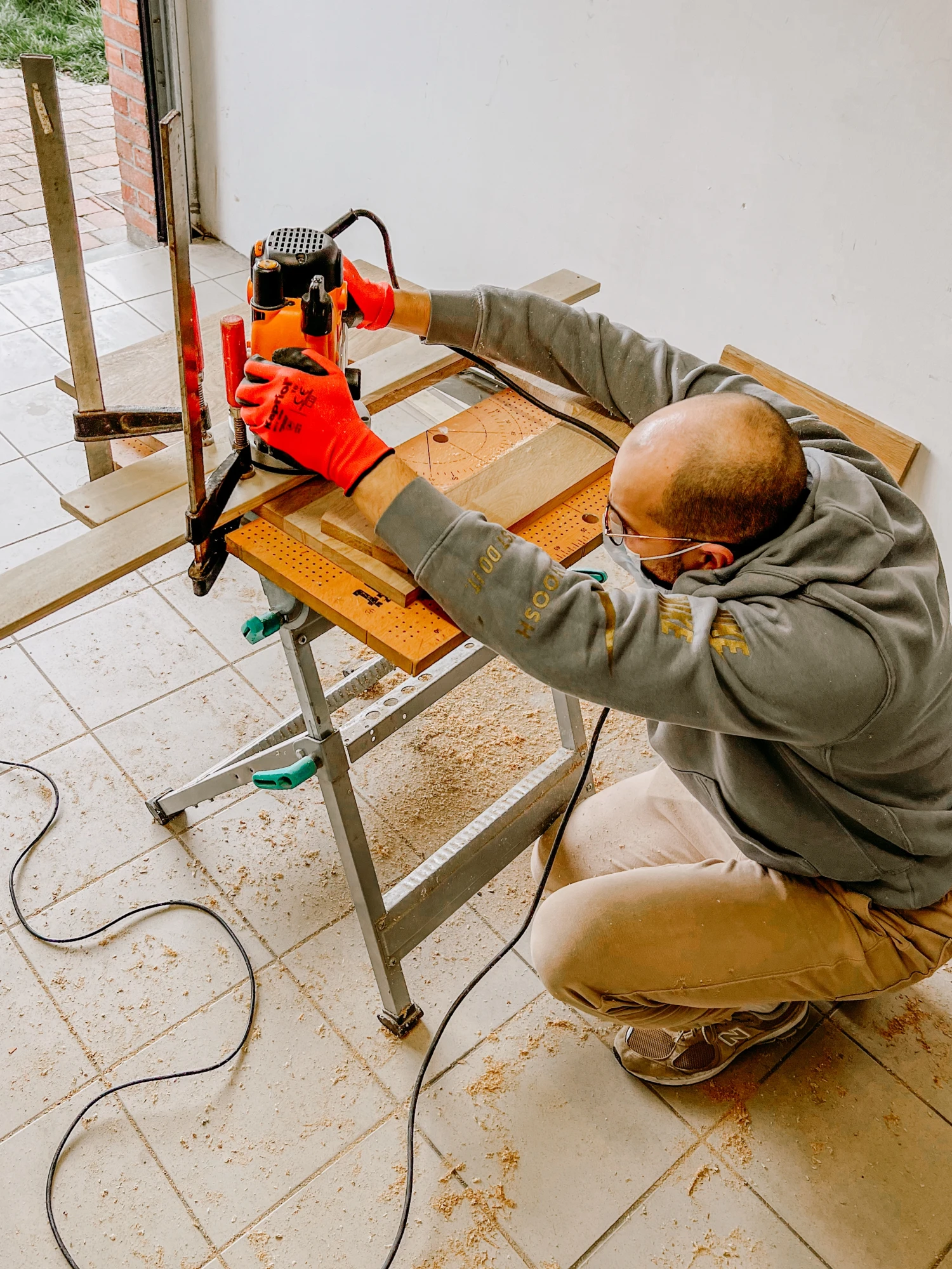 Homme travaillant le bois avec une défonceuse sur un établi. Menuiserie. photographe-lille